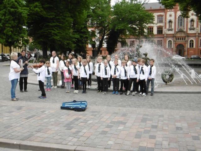 Zingende kinderen voor de fontein